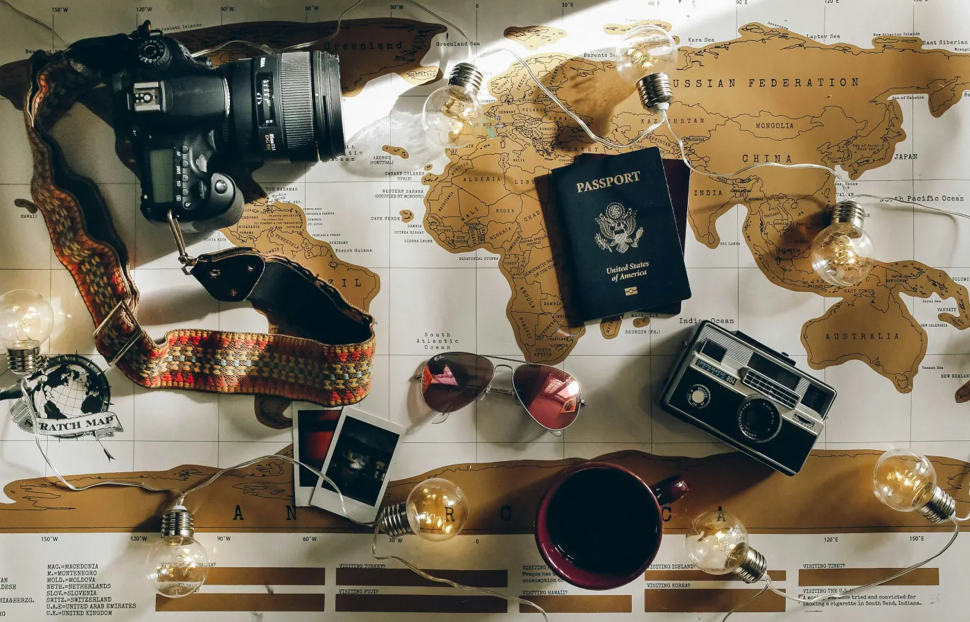 World map with a passport, camera and travel keepsakes